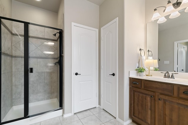 bathroom featuring baseboards, a stall shower, vanity, and tile patterned flooring