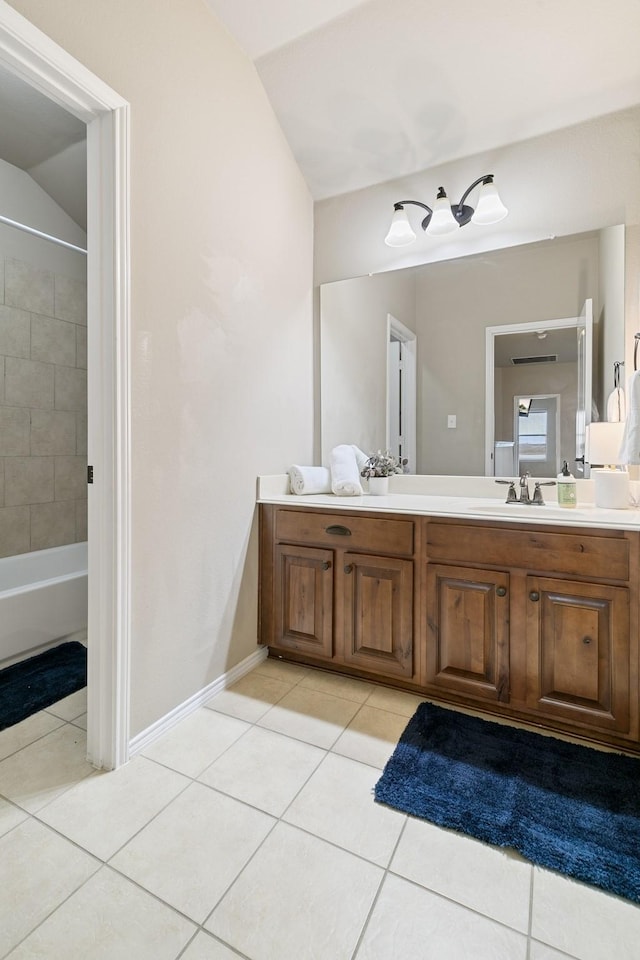 full bath with tile patterned floors, vanity, and vaulted ceiling