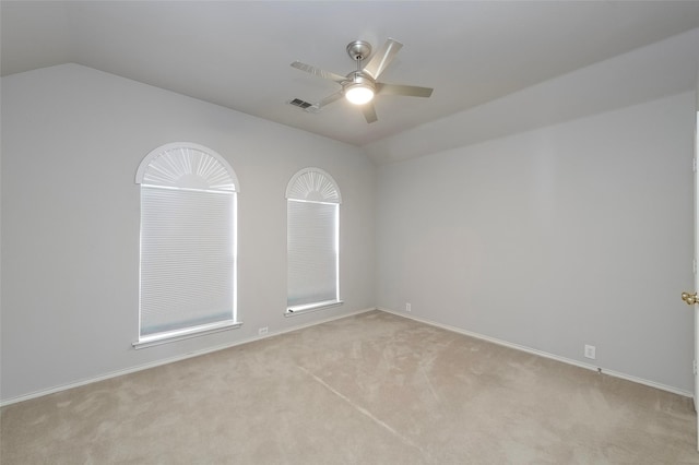 carpeted spare room with ceiling fan and lofted ceiling