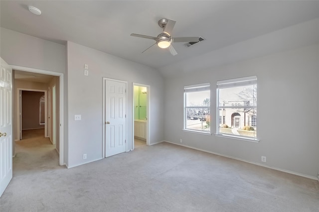 unfurnished bedroom with light carpet, ensuite bathroom, vaulted ceiling, and ceiling fan