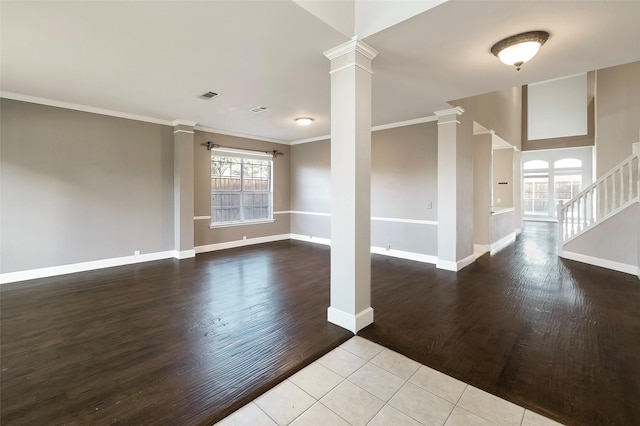 empty room with ornate columns, ornamental molding, and light hardwood / wood-style floors