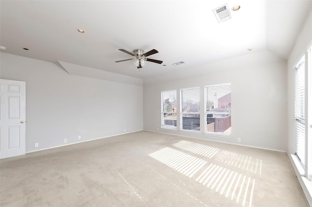 spare room featuring ceiling fan, light colored carpet, and vaulted ceiling