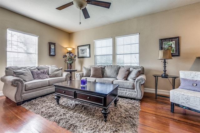 living room featuring ceiling fan and dark hardwood / wood-style floors