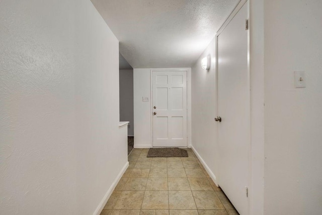 hall featuring a textured ceiling