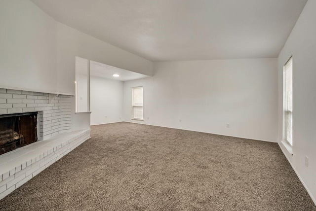 unfurnished living room with a fireplace, carpet, and a wealth of natural light