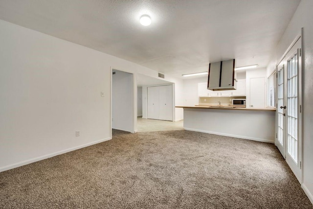 unfurnished living room with light colored carpet