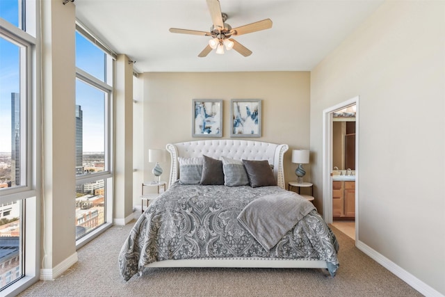 bedroom with ensuite bath, ceiling fan, and light carpet