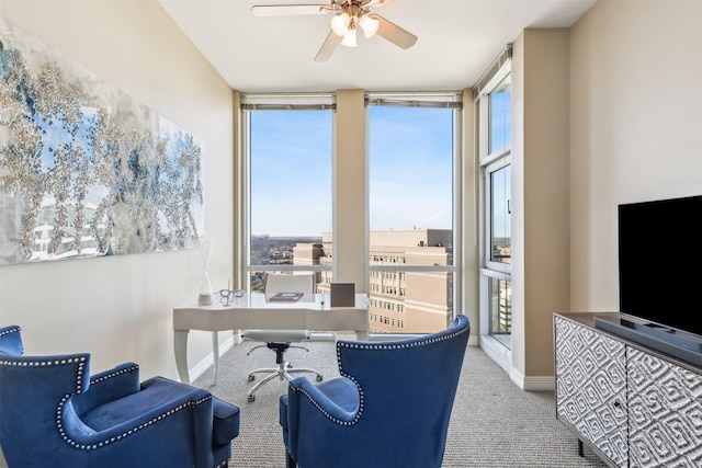 office area with ceiling fan, expansive windows, light colored carpet, and a wealth of natural light