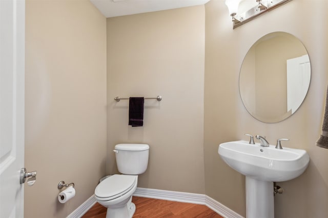 bathroom with hardwood / wood-style floors, toilet, and sink