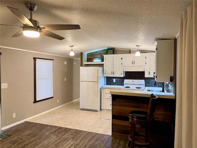 kitchen with backsplash, white appliances, vaulted ceiling, white cabinetry, and hanging light fixtures