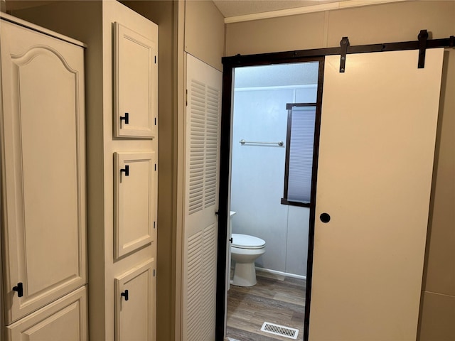 bathroom featuring toilet and wood-type flooring