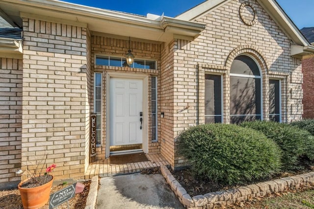 property entrance featuring brick siding