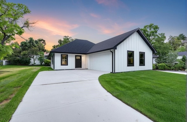 modern inspired farmhouse featuring a lawn and a garage