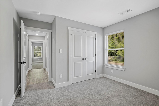 unfurnished bedroom with light colored carpet