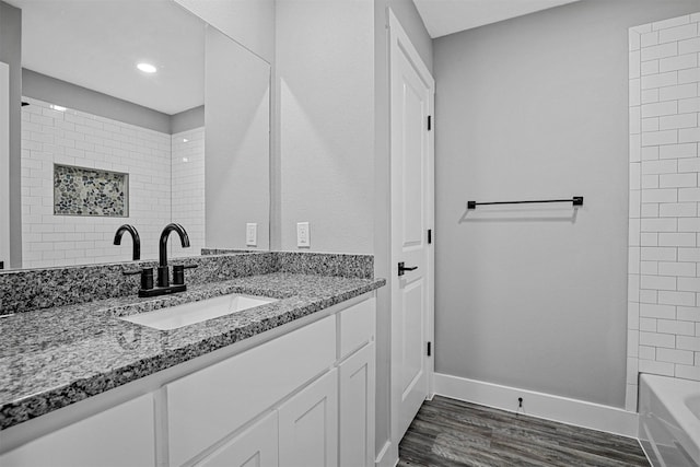 bathroom with vanity, wood-type flooring, and tiled shower / bath combo