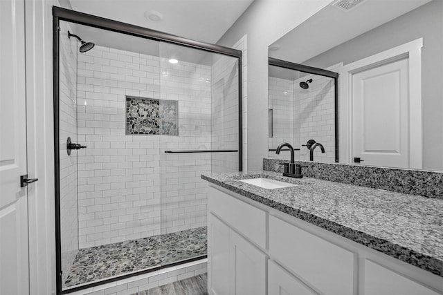 bathroom featuring vanity, an enclosed shower, and hardwood / wood-style flooring