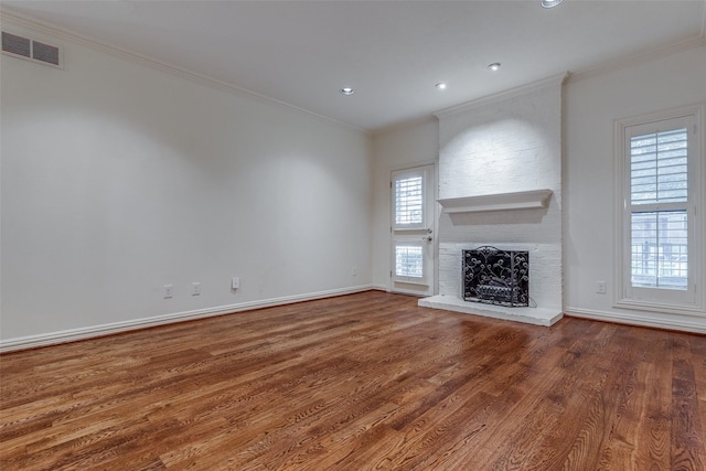 unfurnished living room with crown molding, hardwood / wood-style floors, and a brick fireplace