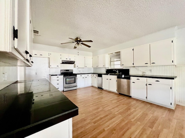 kitchen featuring white cabinetry, ceiling fan, stainless steel appliances, and light wood-type flooring