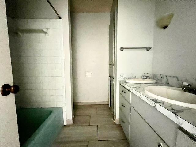 bathroom featuring tile patterned flooring, vanity, and a bath