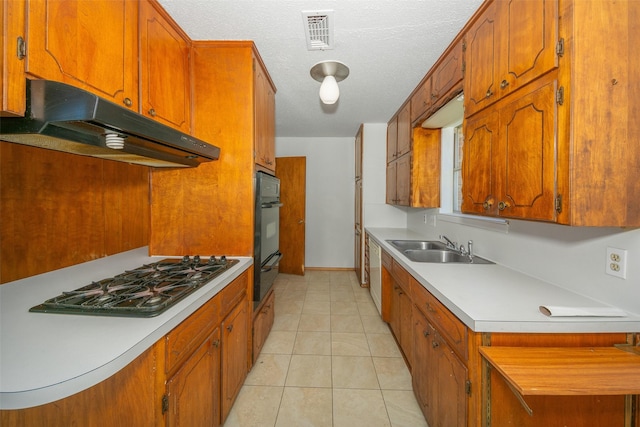 kitchen featuring sink, white appliances, a textured ceiling, and light tile patterned floors