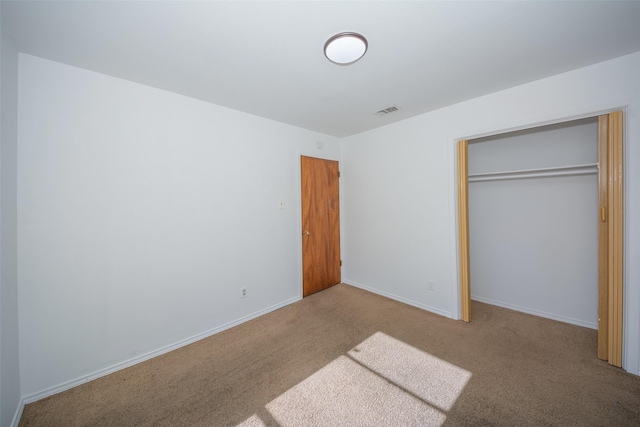 unfurnished bedroom featuring carpet flooring and a closet