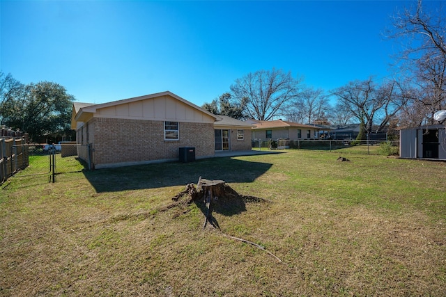 back of property featuring a yard, a shed, and central air condition unit