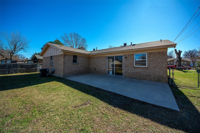 rear view of property with a patio area, a yard, and central AC