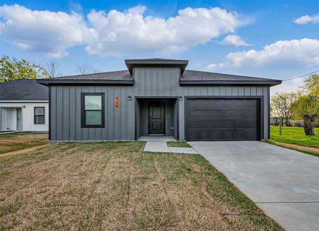 view of front of home featuring a front yard, an attached garage, board and batten siding, and concrete driveway