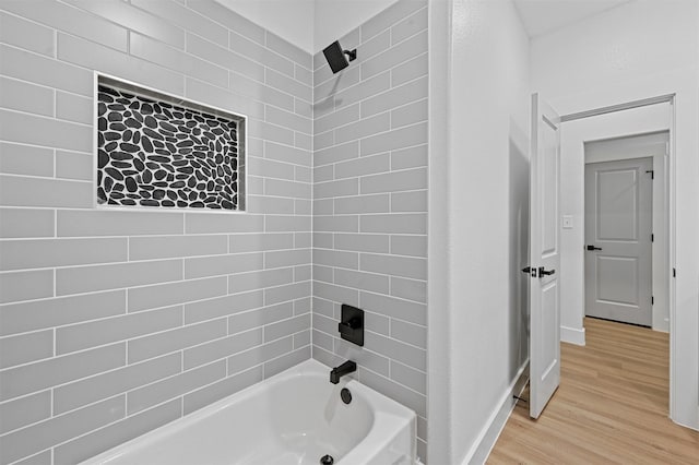 bathroom with tiled shower / bath combo and hardwood / wood-style flooring