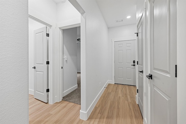 hallway with light hardwood / wood-style floors