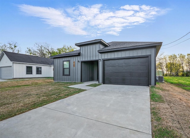 view of front of home with concrete driveway, board and batten siding, a front lawn, a garage, and central AC