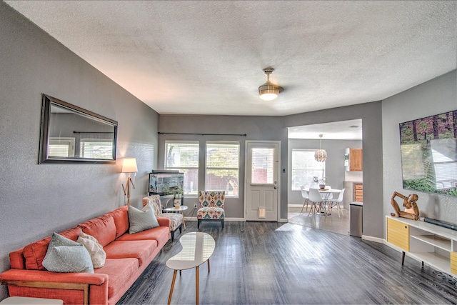 living room with a textured ceiling, dark hardwood / wood-style floors, and ceiling fan