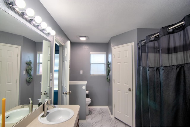 bathroom featuring plenty of natural light, toilet, a textured ceiling, and vanity