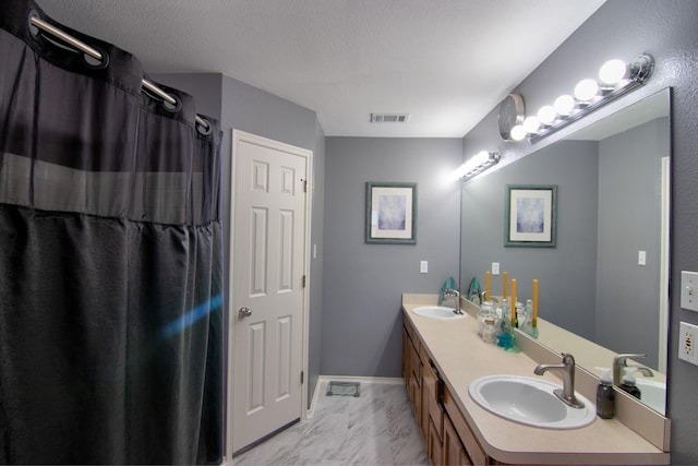 bathroom with vanity and a textured ceiling