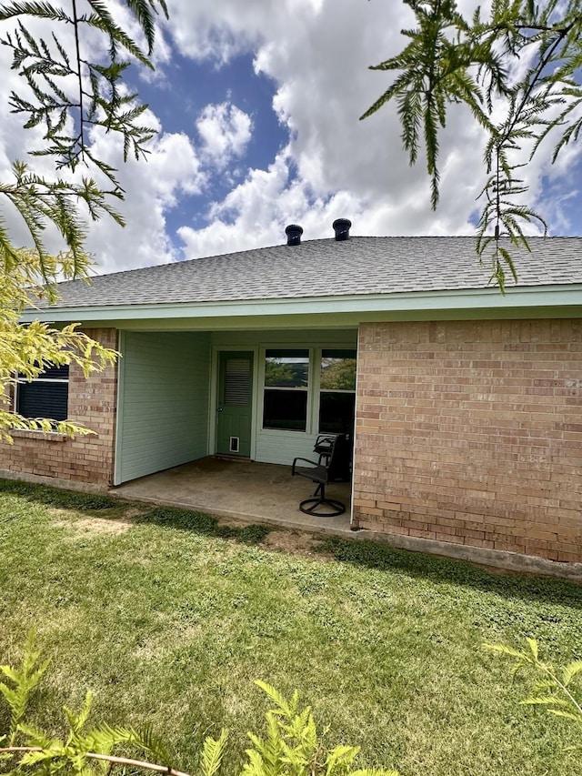 back of property with a yard and a patio