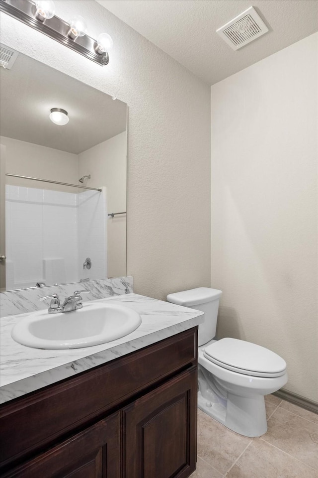 bathroom with tile patterned floors, a shower, vanity, and toilet