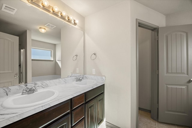 bathroom featuring tile patterned floors, vanity, and a tub to relax in