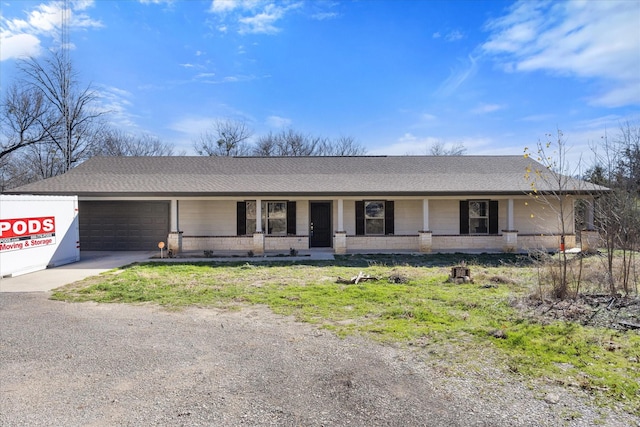 ranch-style home featuring a porch and a garage