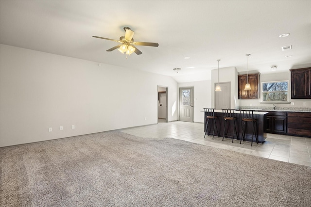 living room featuring ceiling fan, sink, plenty of natural light, and light carpet