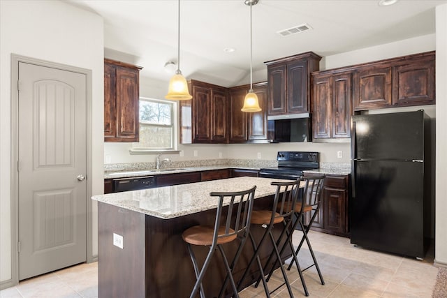 kitchen featuring dark brown cabinetry, a center island, sink, decorative light fixtures, and black appliances