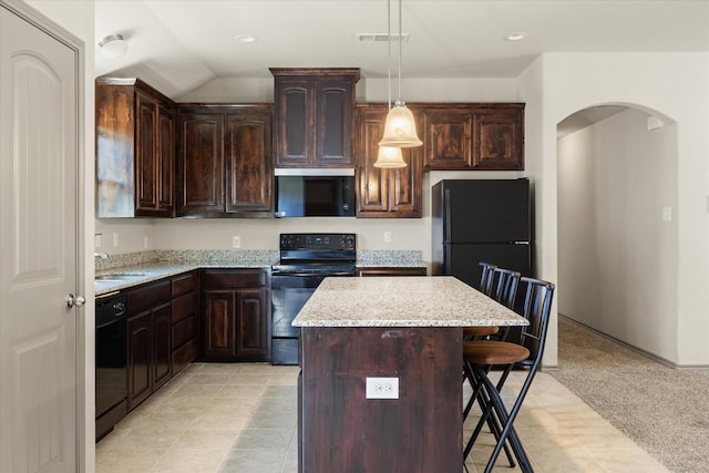 kitchen with pendant lighting, light carpet, black appliances, a kitchen breakfast bar, and a kitchen island