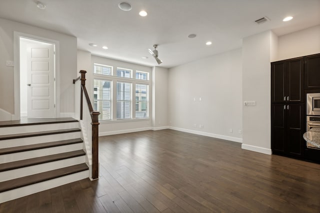 unfurnished living room with dark wood-type flooring