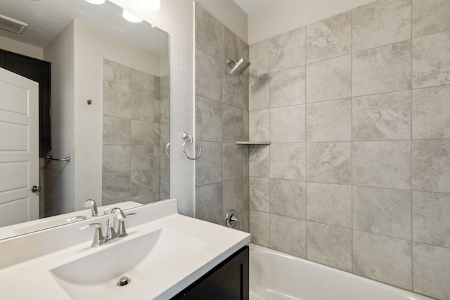 bathroom with vanity and tiled shower / bath combo