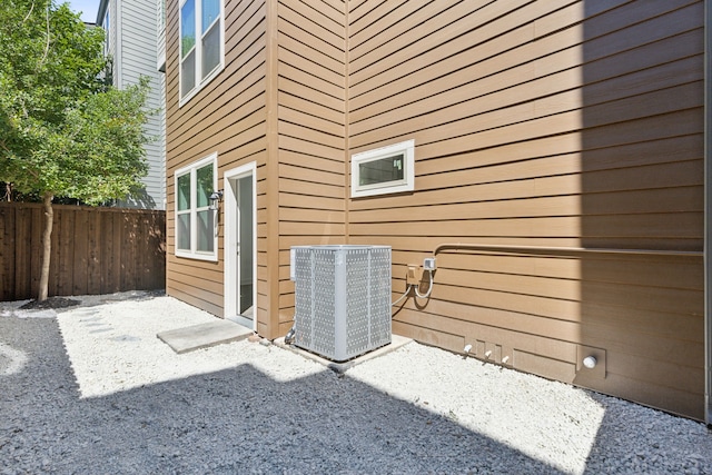 view of side of property with a patio and central AC unit