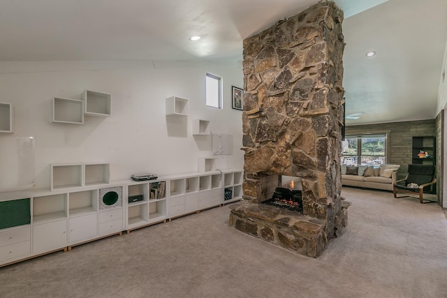 living room with a fireplace, light colored carpet, and vaulted ceiling