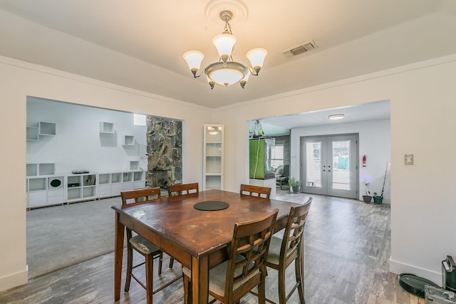 dining area with a chandelier and french doors