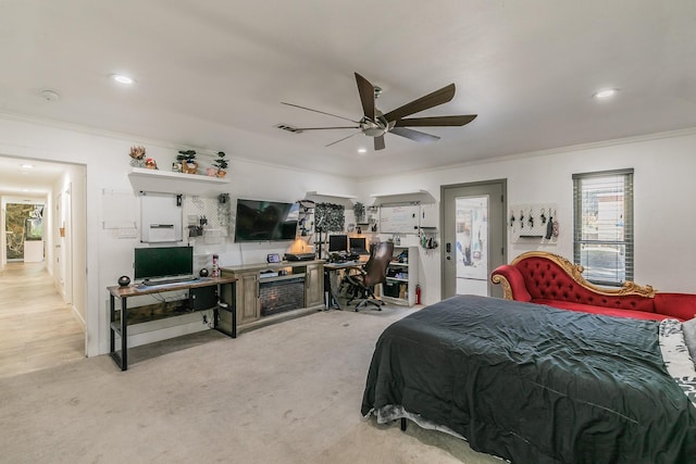 carpeted bedroom featuring ceiling fan and crown molding