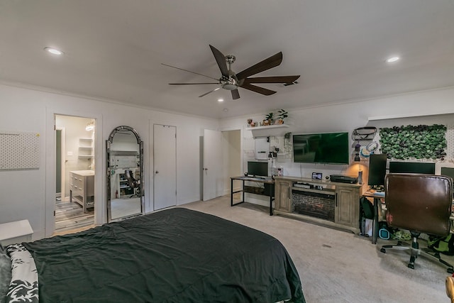 carpeted bedroom featuring ceiling fan, ornamental molding, and ensuite bath