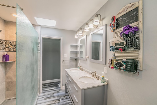 bathroom featuring hardwood / wood-style floors, vanity, and a skylight