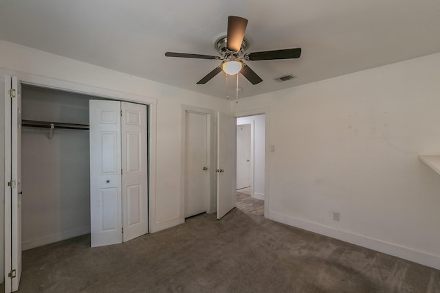 unfurnished bedroom with ceiling fan and dark colored carpet